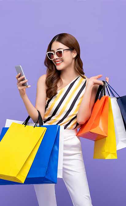 A woman holding a phone and shopping bags